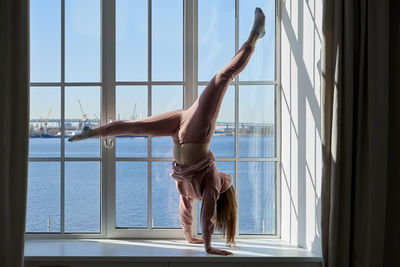 Woman standing by window at home