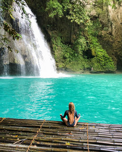 Woman meditating but the waterfall