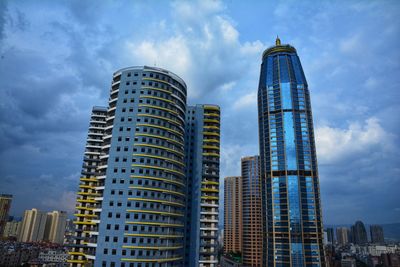 Low angle view of buildings against cloudy sky