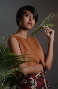 Beautiful young woman standing against gray background