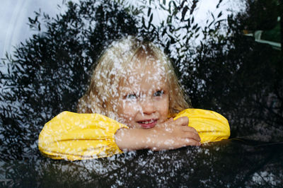 Portrait of little girl looking through the window 