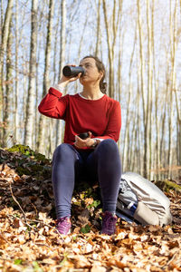 Spanish tourist girl sitting and drinking in the forest