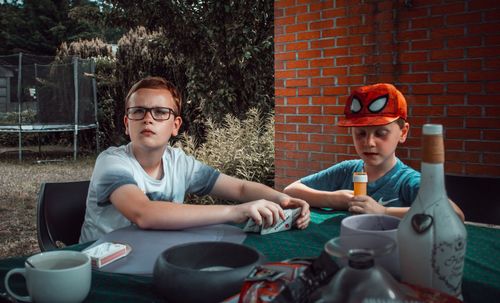 Portrait of happy boy sitting on table