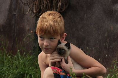 Cute boy holding cat