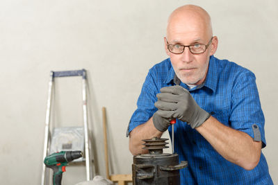 Portrait of carpenter holding screwdriver at workshop