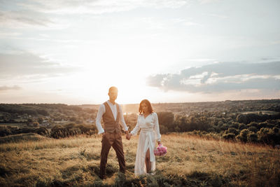 Couple on field against sky