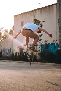 Full length of man skateboarding at playground during sunset