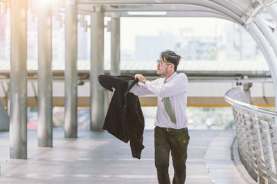 Mid adult businessman wearing blazer on elevated walkway