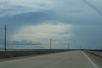 View of concrete highway against cloudy sky