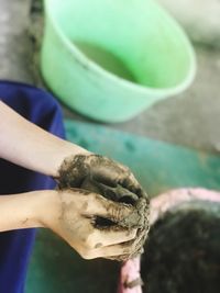 Close-up of hand molding a shape with mud