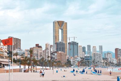 View of skyscrapers in city against cloudy sky