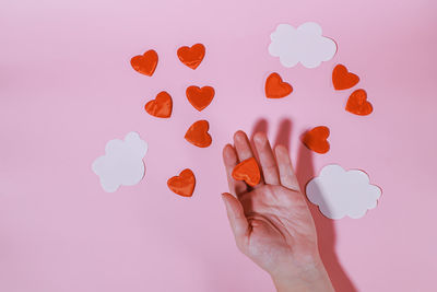 Cropped hand holding heart shape against white background