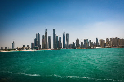 Calm blue sea with cityscape in background