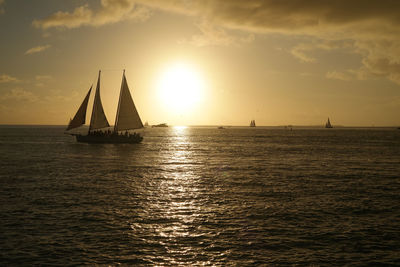 Sailboat sailing on sea against sky during sunset