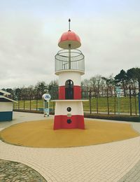 View of red tower against cloudy sky