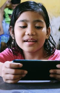 Portrait of smiling girl holding mobile phone