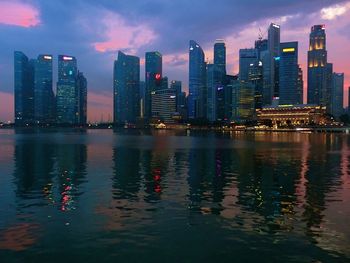 Scenic view of river and illuminated city buildings against sky