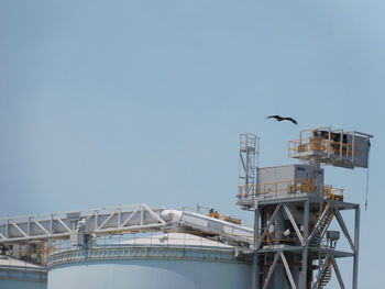 Low angle view of crane against clear sky