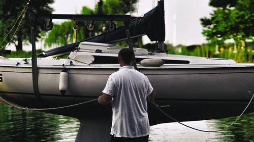 Rear view of man standing by boat