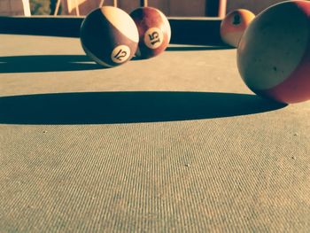 Close-up of pool balls on table during sunny day