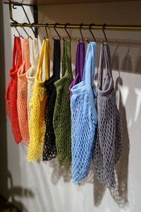 Colorful eco-friendly shopping string bags on hangers, multicolor mesh woven eco-bags