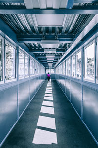 Rear view of woman walking in covered walkway