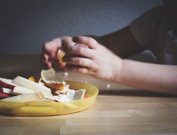 Close-up of hand holding ice cream on table