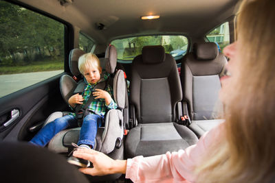 Mother and son sitting in car