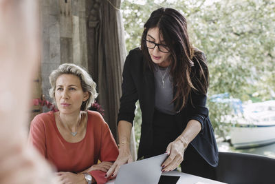 Businesswoman standing by thoughtful colleague in portable office truck