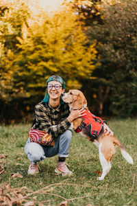 Side view of man with dog on grassy field