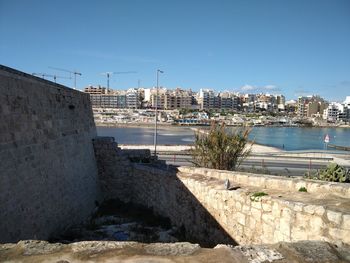 River by buildings against clear sky