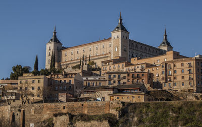 The alcazar, an ancient fortification on a hilltop, and old town buildings in toledo, spain, europe.