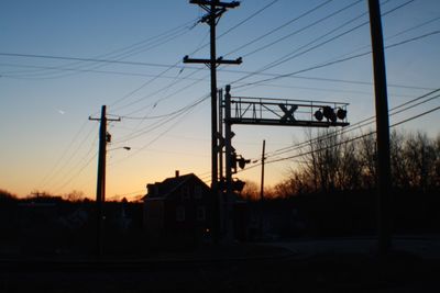 Electricity pylon against sky at sunset