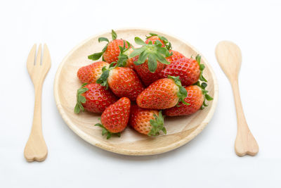 Directly above shot of strawberries in plate against white background