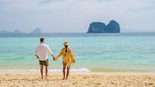 Rear view of woman standing at beach