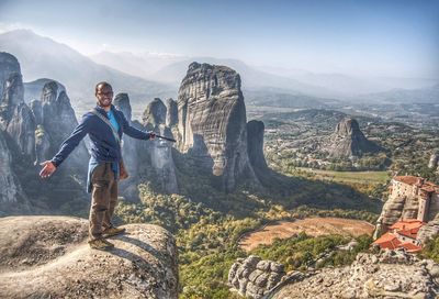 Young man on rock against sky