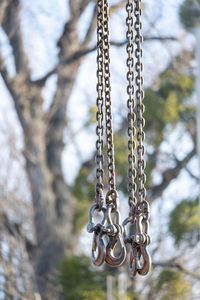 Low angle view of chain against trees