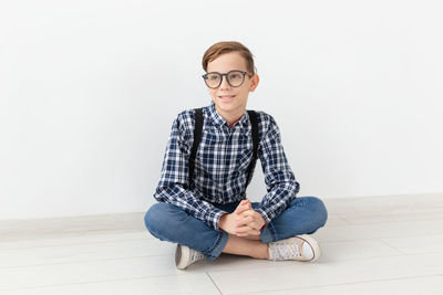 Portrait of smiling man sitting against wall