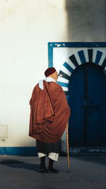 Rear view of woman standing against wall