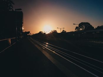 Railroad tracks against sky during sunset