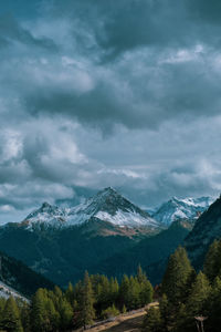 Lonely mountain in a cloudy sky, with a forest in front of it 