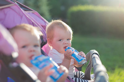 Portrait of cute girls drinking outdoors