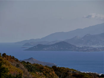 Scenic view of sea and mountains against sky