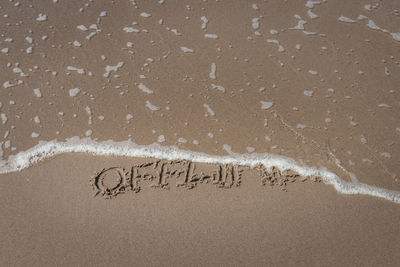 High angle view of text on sand at beach