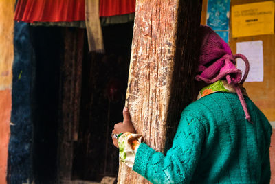 Woman standing by wood