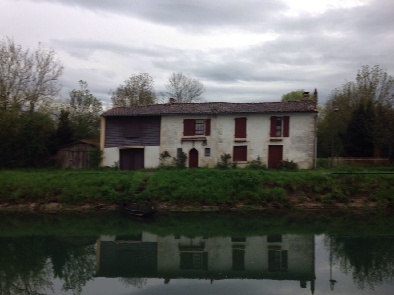 architecture, built structure, building exterior, sky, tree, cloud - sky, house, water, grass, reflection, cloud, bare tree, cloudy, nature, lake, tranquility, day, waterfront, tranquil scene, outdoors