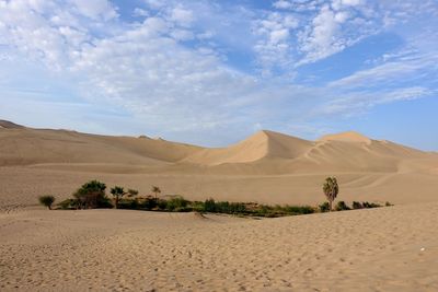 Scenic view of desert against cloudy sky