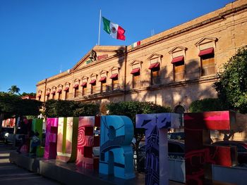 Low angle view of flags hanging against buildings