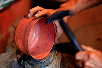 Cropped hands making bowl at workshop