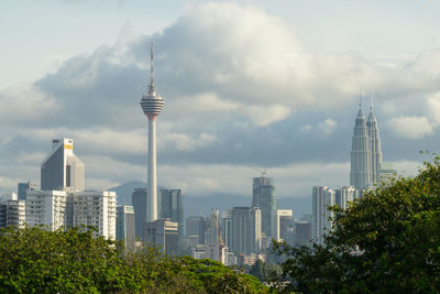 Skyscrapers in city against cloudy sky